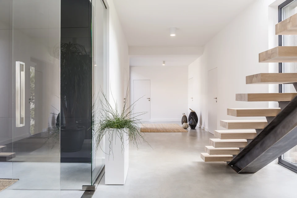 Intérieur résidentiel moderne avec escalier flottant à marches en bois et structure métallique noire