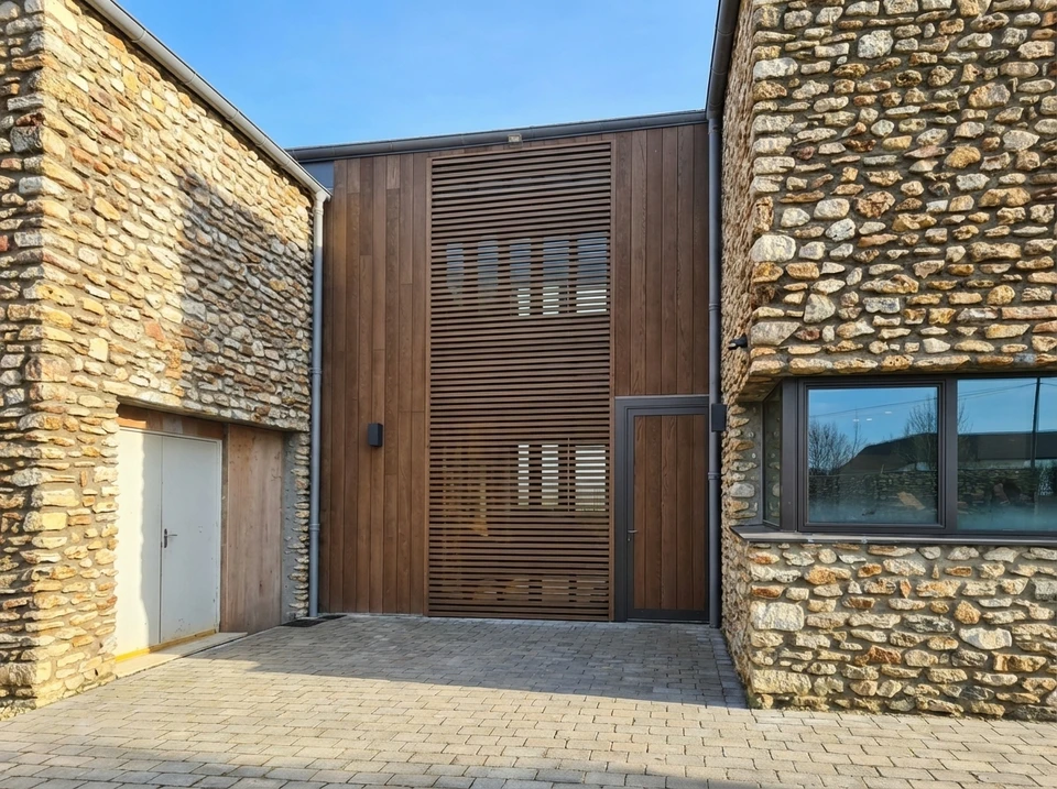 Entrepôt industriel de stockage de matériaux de construction avec rangées d'étagères cantilever bleues chargées de planches et poutres en bois