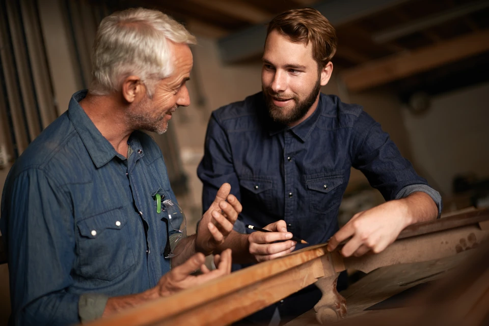 Atelier de menuiserie avec artisan concentré travaillant sur établi, portant protection auditive