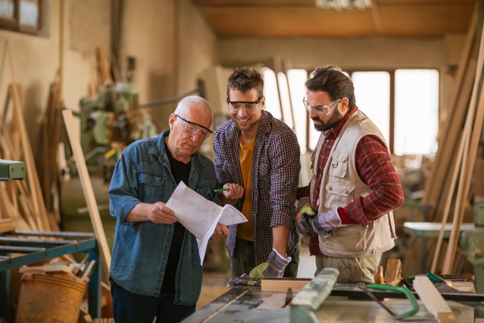 Intérieur moderne avec grande table en bois massif au premier plan, mise en scène avec accessoires décoratifs et plantes