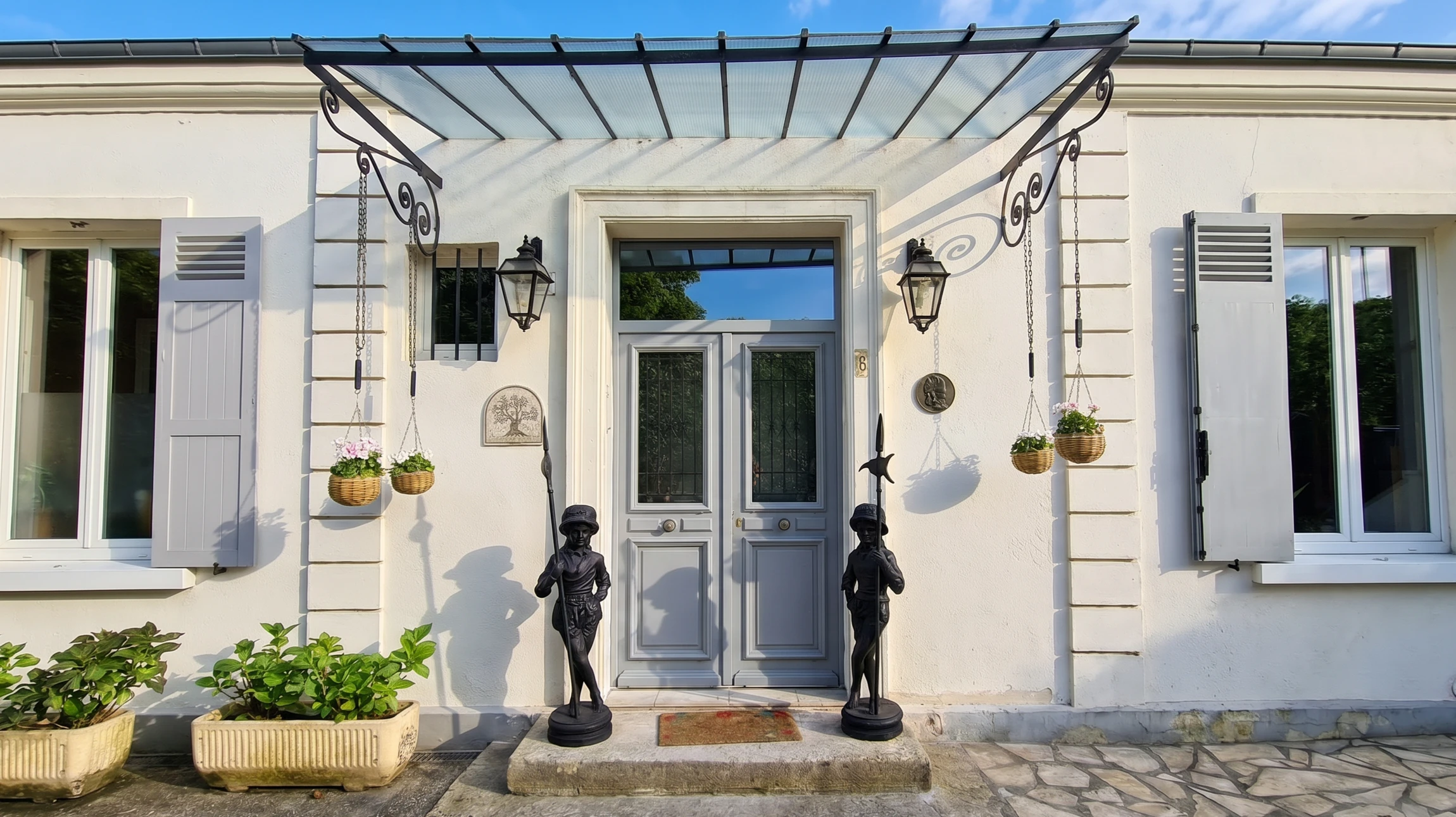 Entrée moderne d'une habitation avec porte en bois naturel à panneaux horizontaux et insert vitré vertical